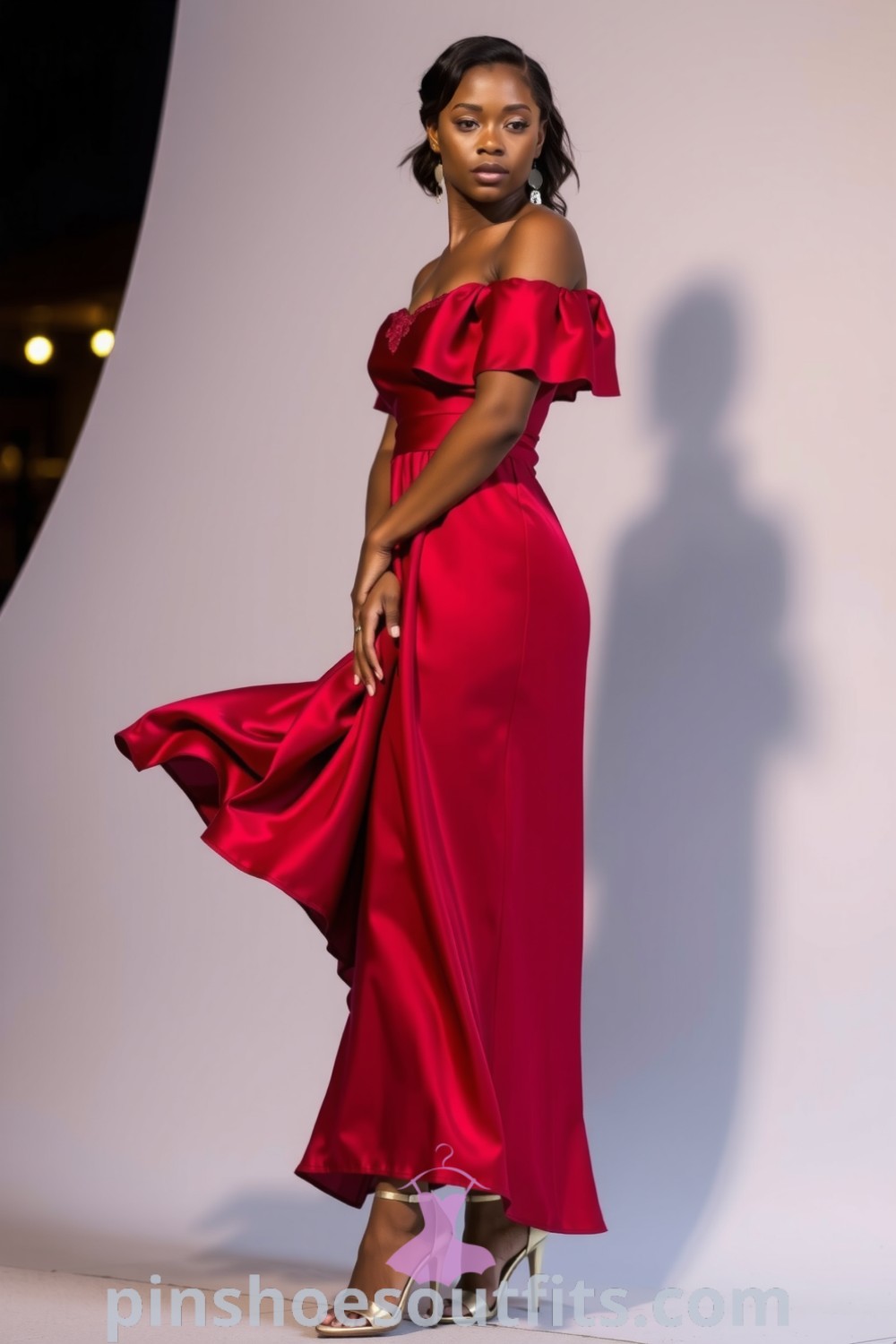 Elegant black woman in a flowing off-the-shoulder crimson satin dress with lace trim, embodying timeless allure and chic elegance for a romantic dinner. pinshoesoutfits.com