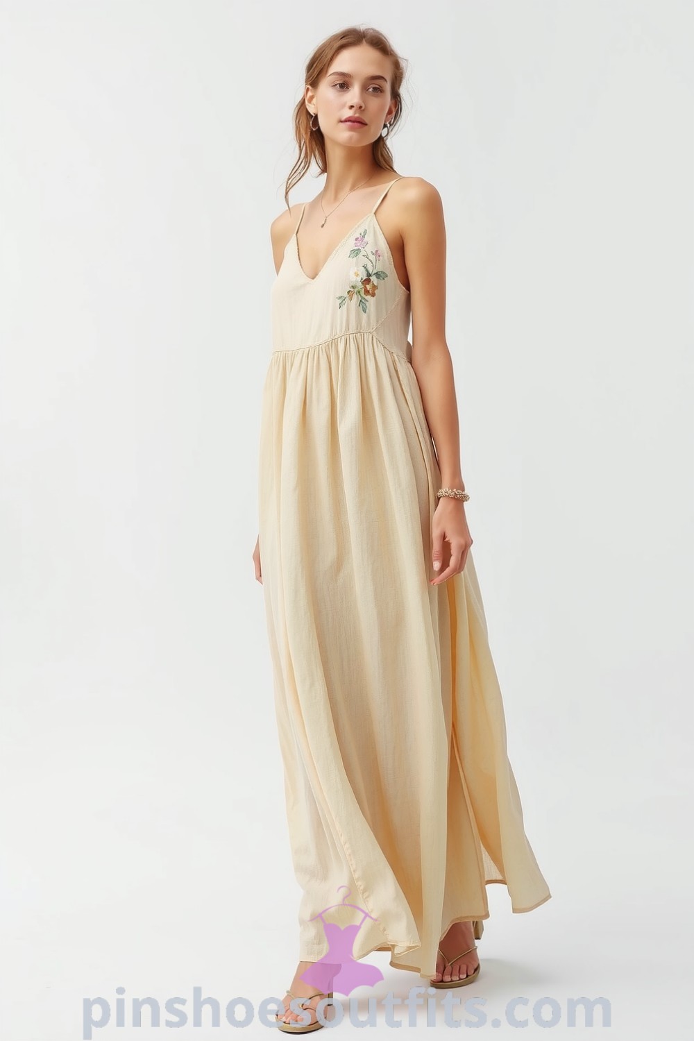 Woman in a flowing linen maxi dress with floral embroidery, showcasing a relaxed and chic style perfect for casual outings. pinshoesoutfits.com