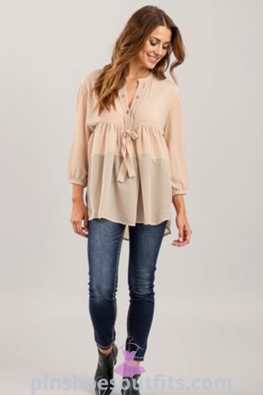 A woman in a soft chiffon blouse layered over high-waisted tailored jeans, paired with chic ankle boots, showcasing casual elegance and style. Perfect for weekend outings. pinshoesoutfits.com